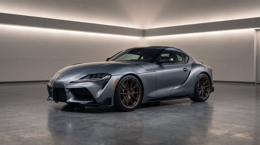 Gray A90 Toyota GR Supra coupe on bronze forged wheels parked in a modern garage with LED strip lighting