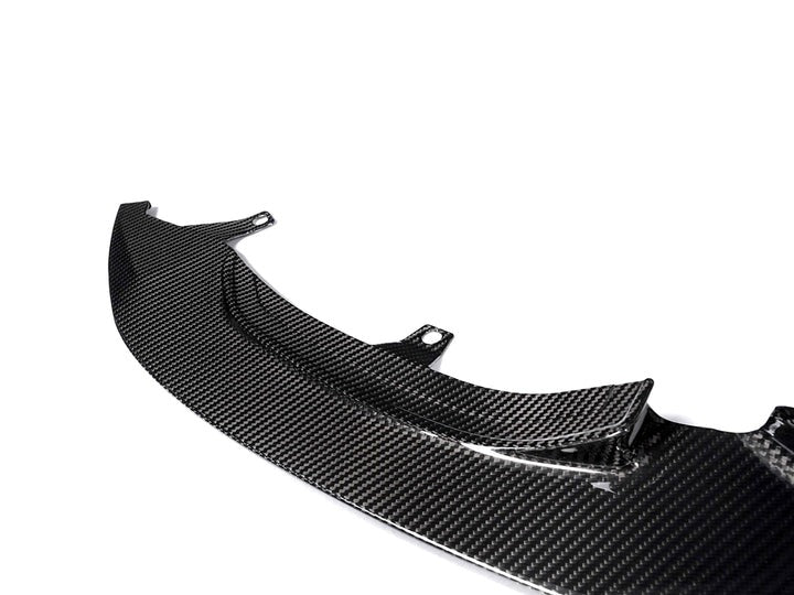 A close up view of AUTOTECKNIC DRY CARBON CORSA FRONT AERO LIP - BMW F80 M3 | F82/ F83 M4 2014+ with white background