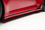 A close up view of TECHART Side Skirts Porsche 992 Turbo /S fitted on a red car with white background