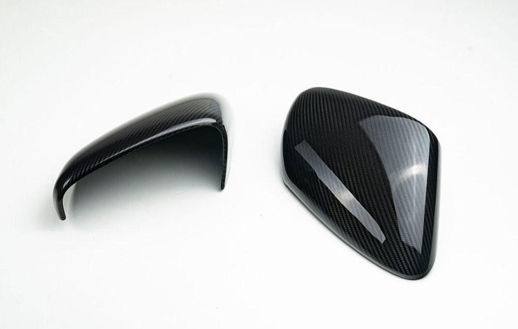 A top view of TECHART Carbon Glossy Side Mirror Trims Porsche 992 Carrera / Targa / Turbo with white background