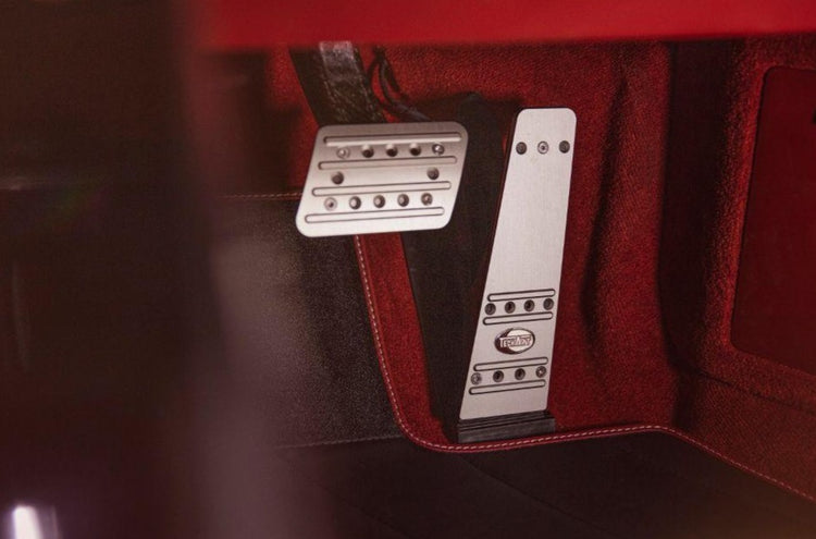 A close up view of TECHART Aluminum Anodized 2 Pieces Pedal Kit w/ TechArt Logo Porsche 992 Carrera / Targa / Turbo fitted in a car
