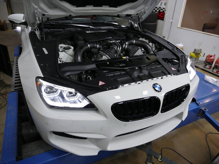 A front view of RK Autowerks F12/F13 M6 S63TU STAGE 1 ECU TUNE fitted on a white BMW