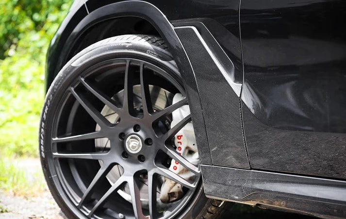 A close up view of AUTOTECKNIC DRY CARBON FIBER FENDER TRIM SET - BMW G06 X6 2020+ fitted on a car