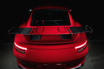 A wide view from the back of TECHART Rear Spoiler Profile Carbon "glossy" for Porsche 991.2 GT3 from MY17 fitted on a red Porsche 