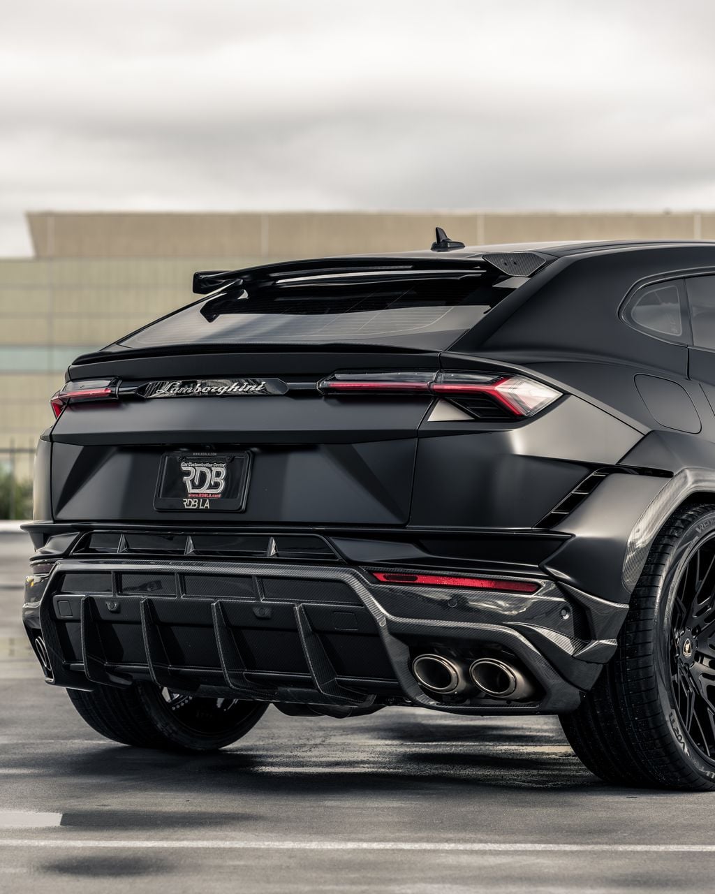 Black Lamborghini Urus rear three-quarter showing the rear diffuser