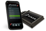A smartphone displaying the Dinan PCU Bluetooth app interface, showing customizable real-time gauges for monitoring engine parameters like boost and timing, and a selection menu for five different performance power levels.