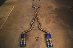 A bird's-eye view of the complete Valvetronic Designs titanium valved sport exhaust system laid out on a concrete floor.