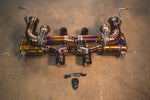 A top-down view of the gold-finish valved catback exhaust system with dual tips and a remote control module.