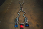 Full view of the Valvetronic Designs Valved Sport Exhaust System for BMW E9x M3 featuring quad burnt blue titanium exhaust tips and a red valve control module.