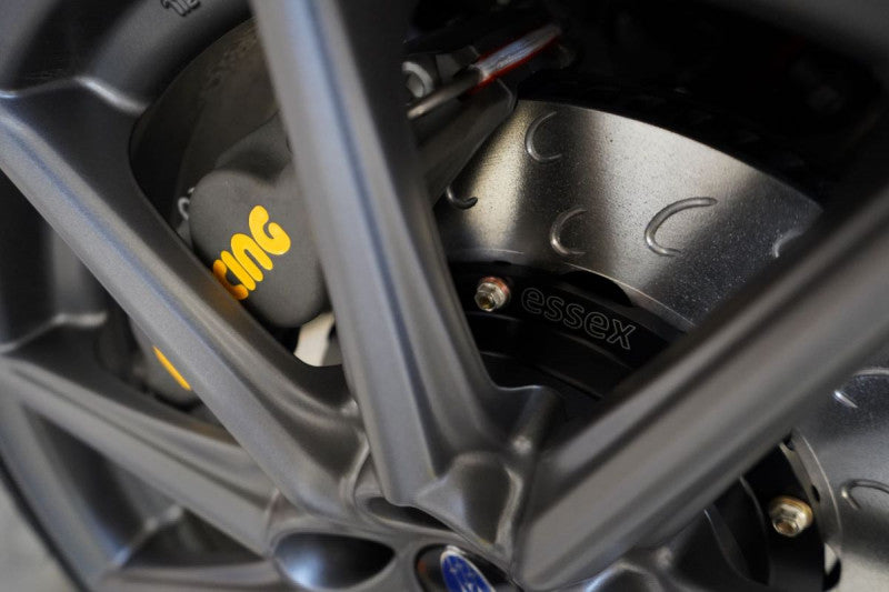 A close up view of a wheel fitted with A front view of a white car with the front wheel fitted with AP Racing by Essex Competition Endurance Brake Kit (Front CP8350/325mm)- Subaru BRZ, Scion FR-S & Toyota GT86/GR86 2013+