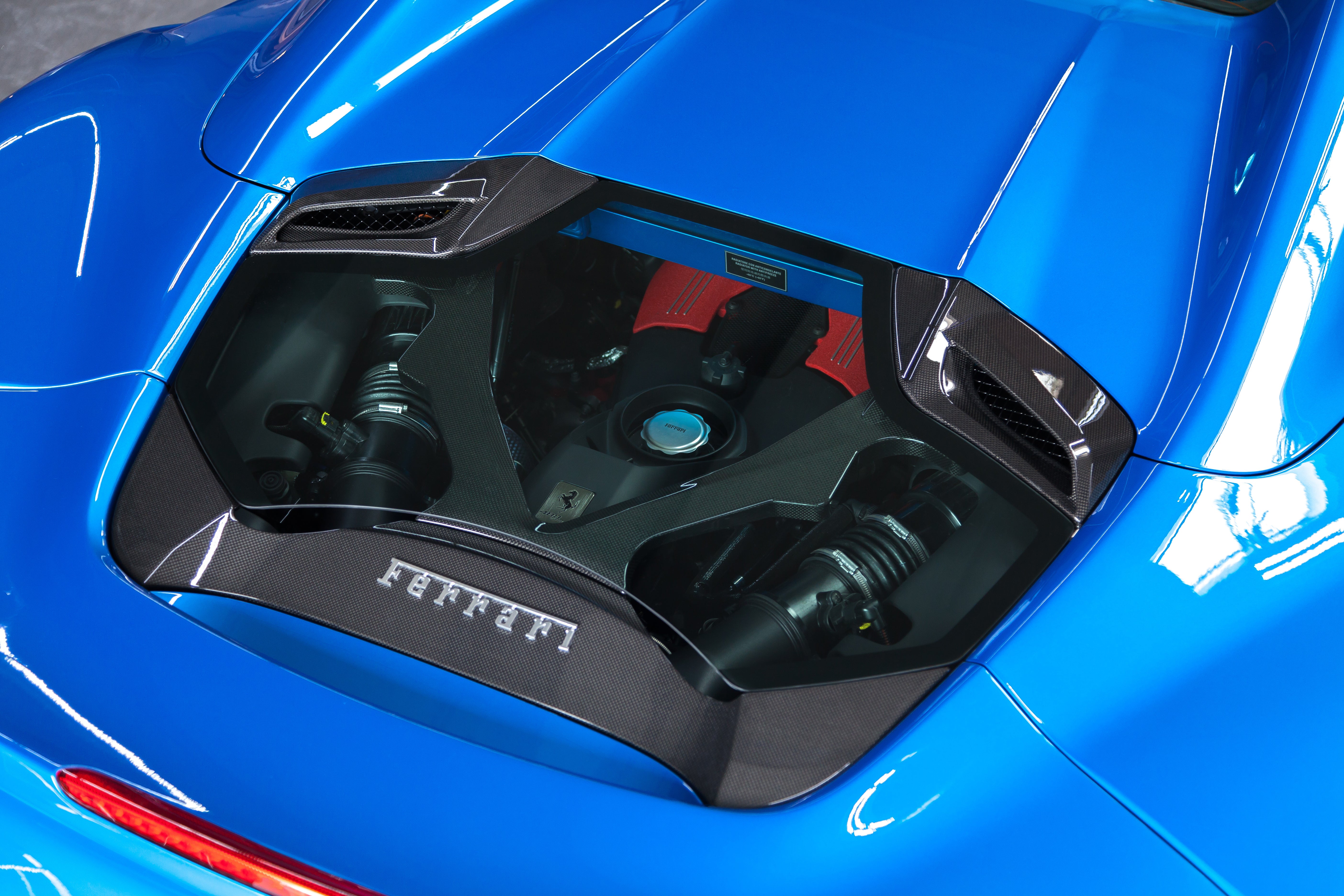 Capristo carbon and glass engine bonnet on a blue Ferrari 488 Spider, angled view