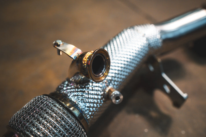 Ferrari 296 GTB GTS Valvetronic exhaust: heat-wrapped pipe section with a bracket and sensor boss, close-up