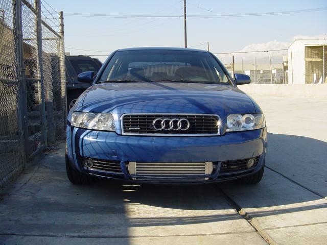 A front view of Evolution Racewerks Audi A4 (B6) Competition Series Front Mount Intercooler (FMIC) Kit fitted on a blue Audi with factory front bumper