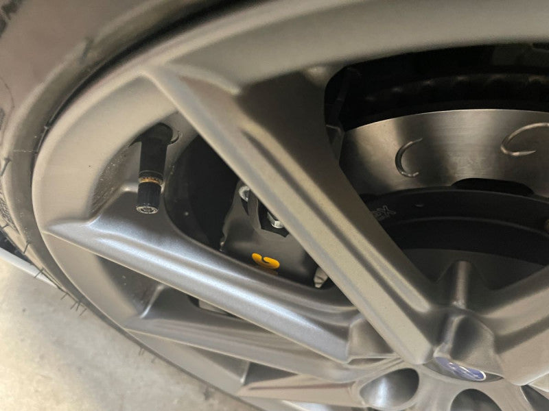 A close up view of a white car with the front wheel fitted with AP Racing by Essex Competition Sprint Brake Kit (Front CP8350/299mm)- Subaru BRZ & Toyota GR86 2022+