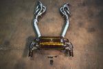 A top-down view of the complete exhaust system including gold muffler, silver mid-pipes with heat shielding, and long-tube headers.