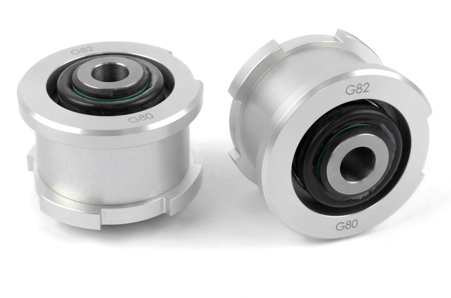 A close-up view of two silver metal tension strut ball joints. Each cylindrical component features a black rubber inner bushing and is engraved with "G82" on the top and "G80" on the bottom of the outer rim.