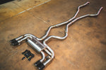 High-angle perspective of the complete stainless steel exhaust layout with the valved muffler and electronic controller kit on a concrete floor.