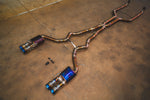 A wide-angle perspective view of the titanium exhaust system, highlighting the purple and blue heat-treated finish.