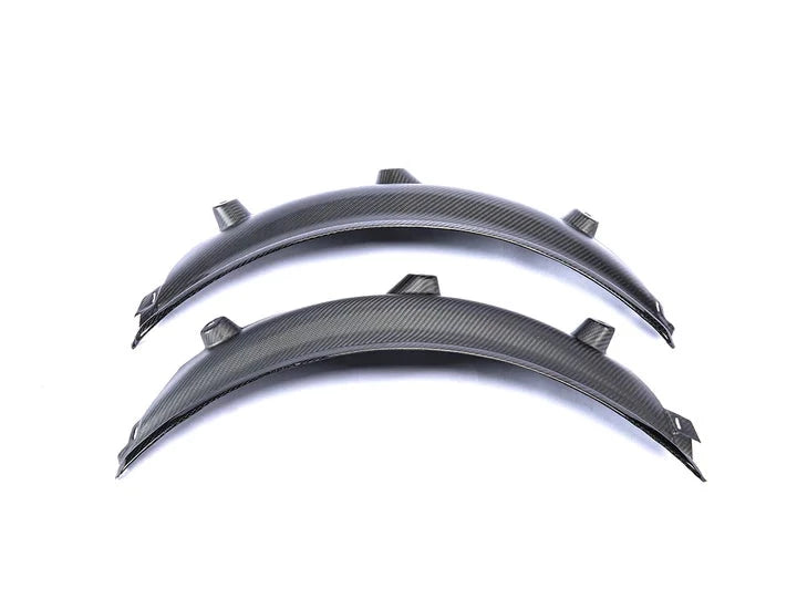 A close up view of AUTOTECKNIC CARBON FIBER REAR WHEEL ARCH EXTENSION SET - BMW G80 M3 2021+ with white background