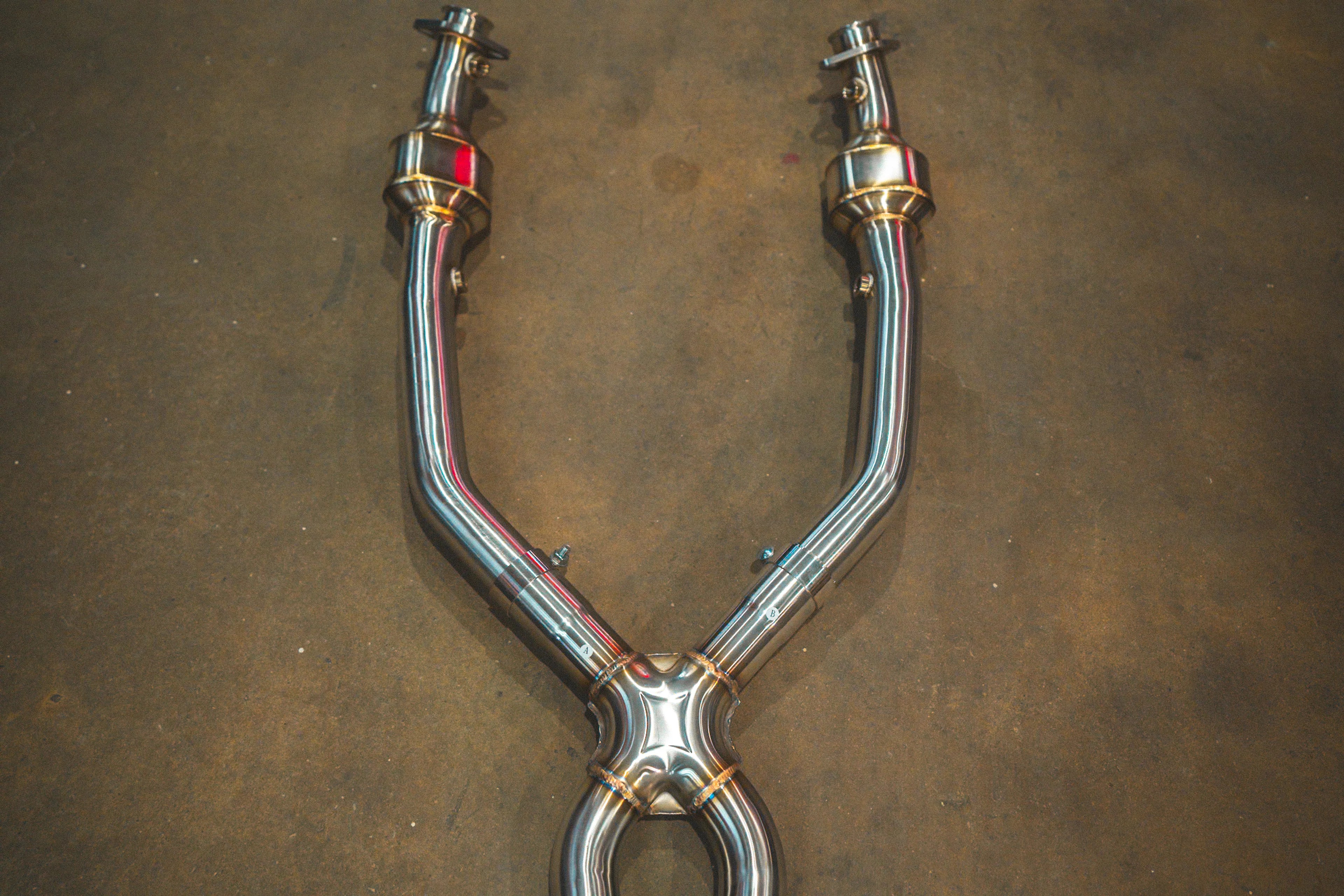 A top-down view focused on the upper Y-section of the exhaust mid-pipe, showcasing the flange connections and the initial X-pipe merge.