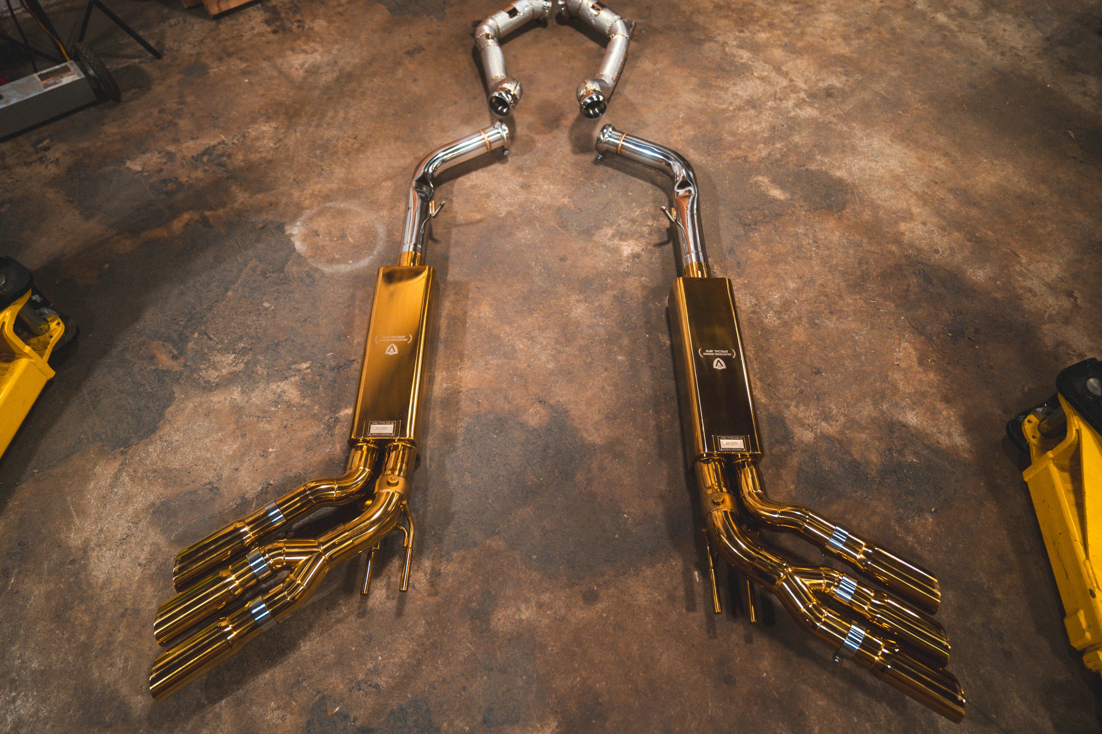 Full component layout featuring gold-plated mufflers, silver connecting pipes, mesh-wrapped downpipes, and the valve control system.