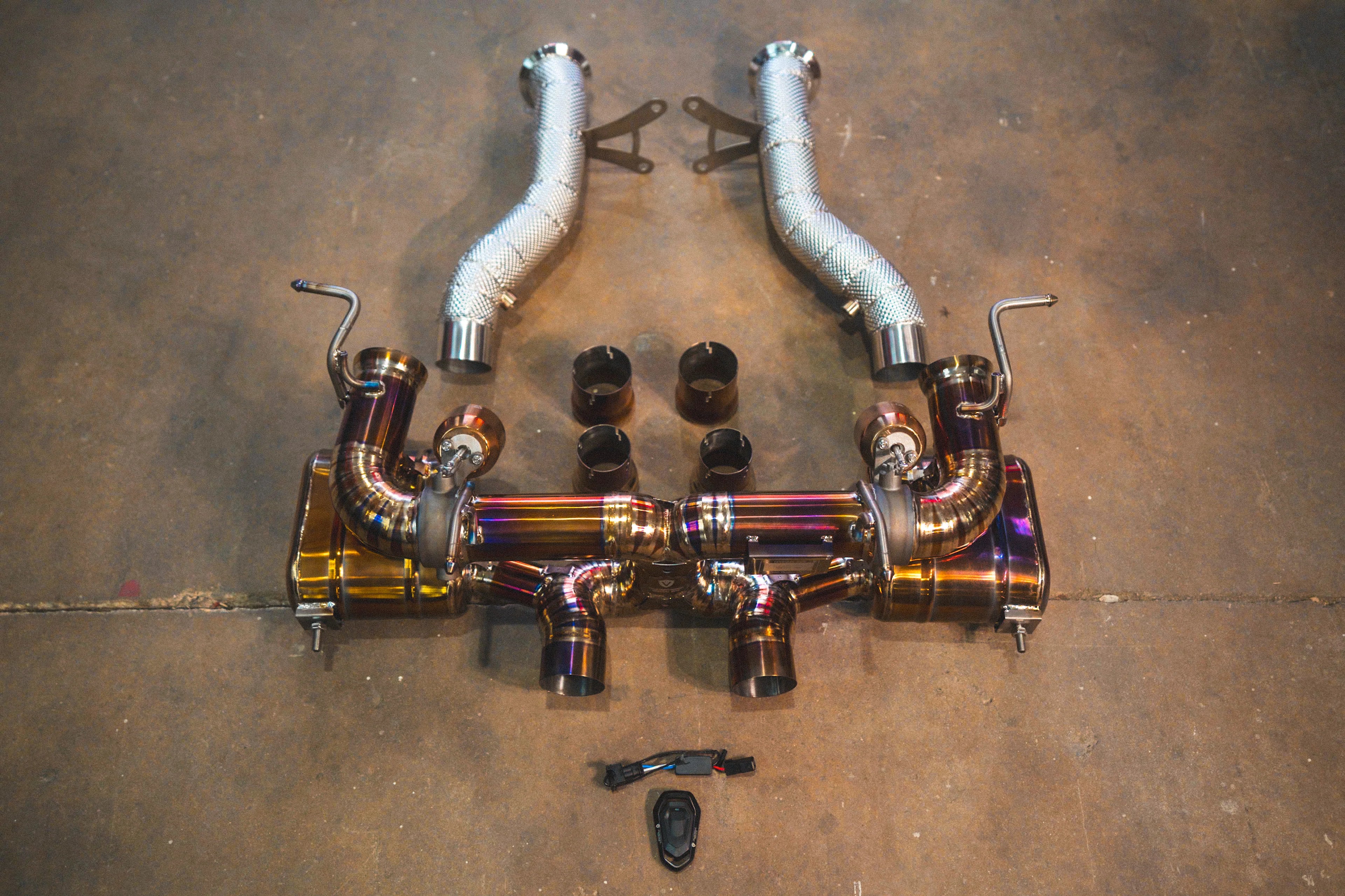 A top-down view showing the gold-finish valved exhaust system paired with silver heat-shielded race free-flow front pipes.
