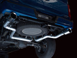 Low underside view of the AWE 0FG split rear pipes routed around the F-150 spare tire