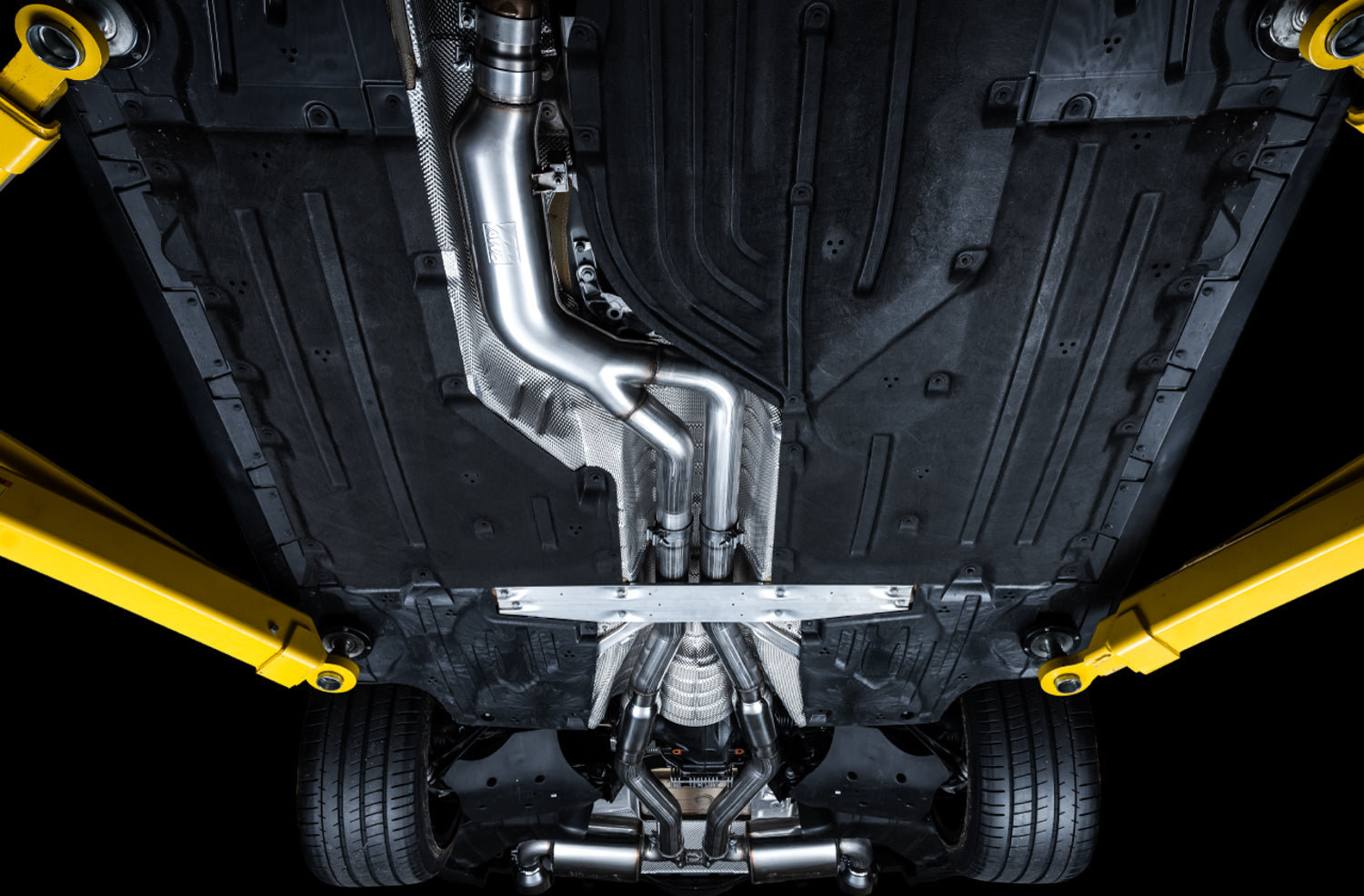 View straight up at an A90 Supra floor showing the AWE Touring system along the tunnel