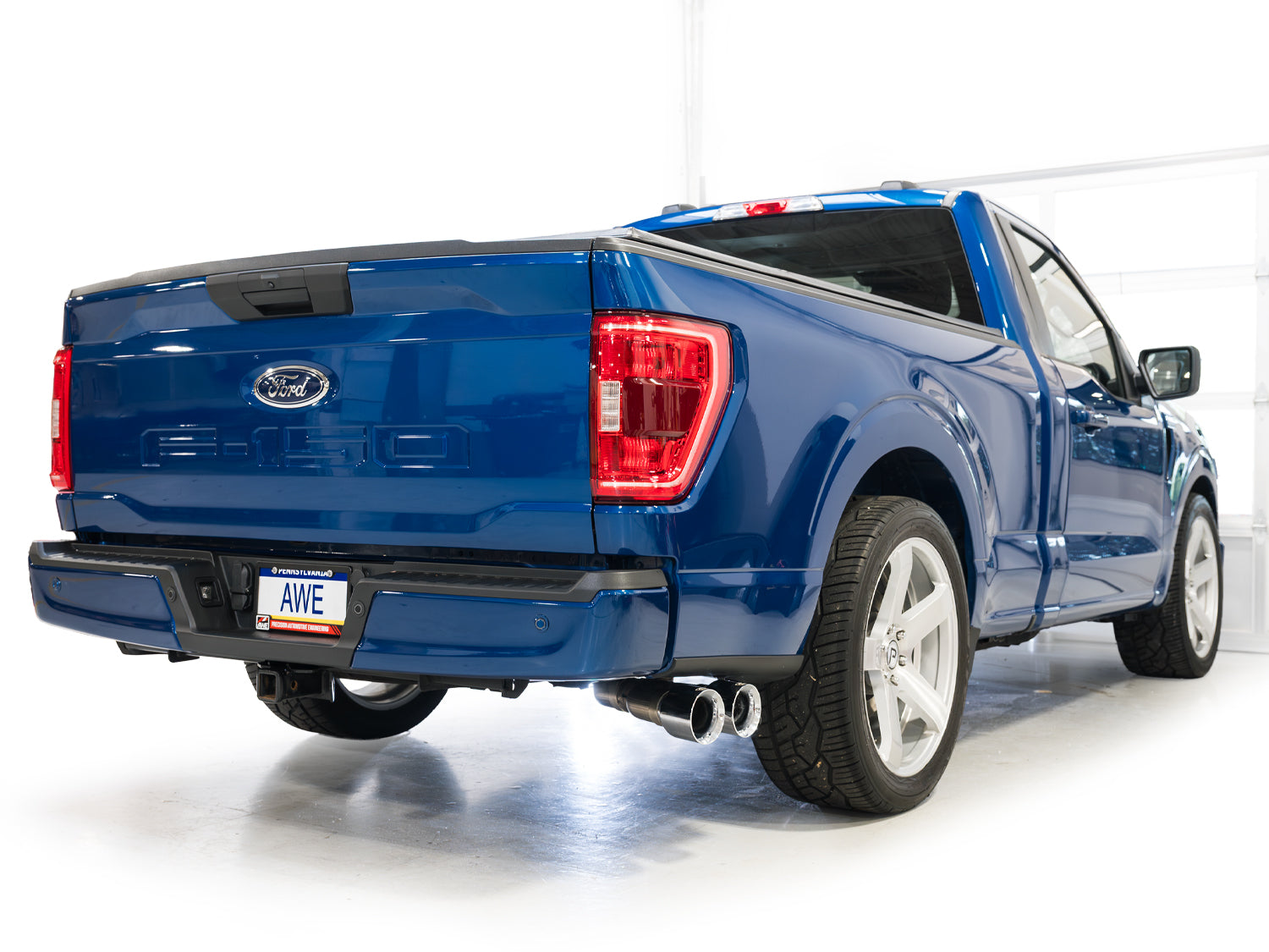 Blue 5.0L F-150 Regular Cab rear three-quarter view with AWE Chrome tips by the rear wheel