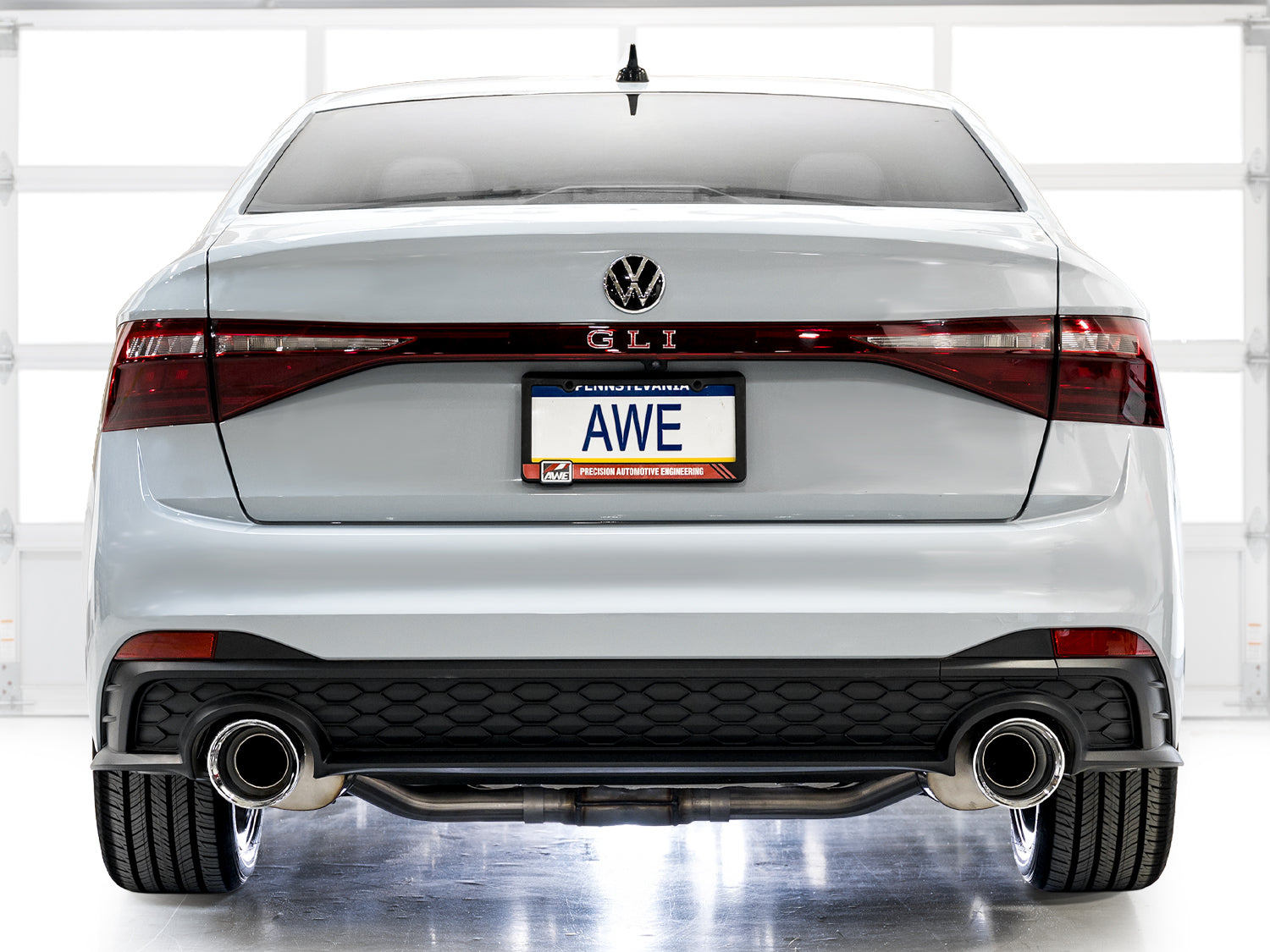 Rear view of a white 2022+ Jetta GLI in a studio fitted with AWE dual exhaust tips