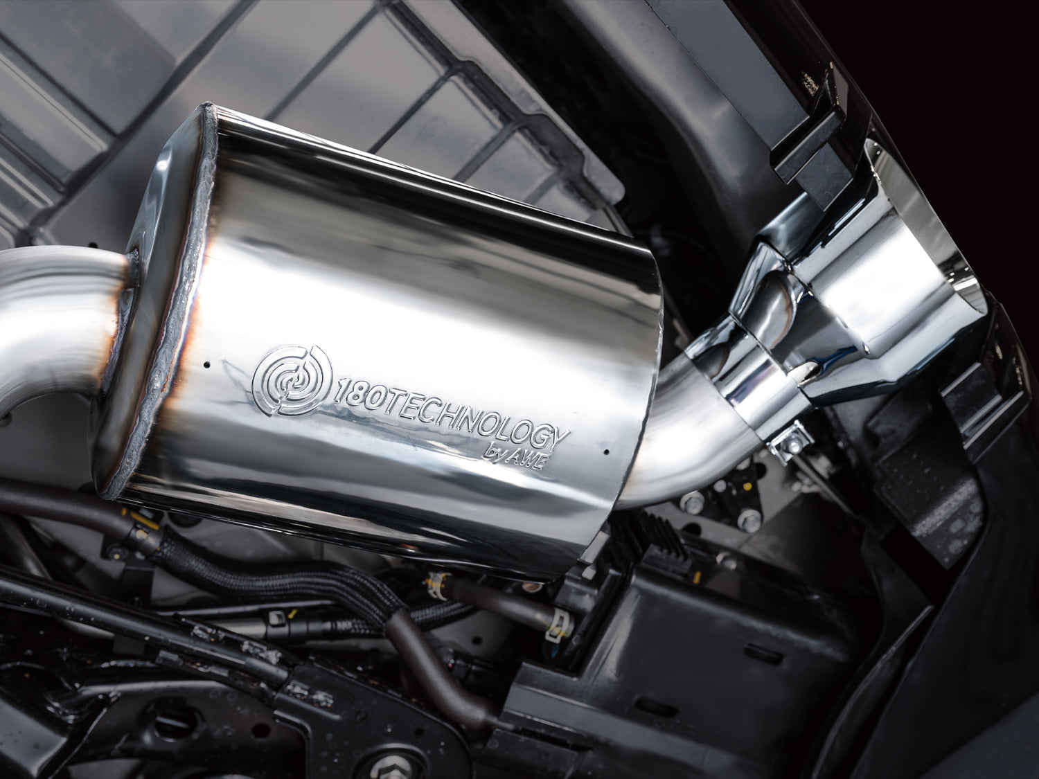 Close-up of an AWE 180 Technology resonator hanging under a Nissan Z