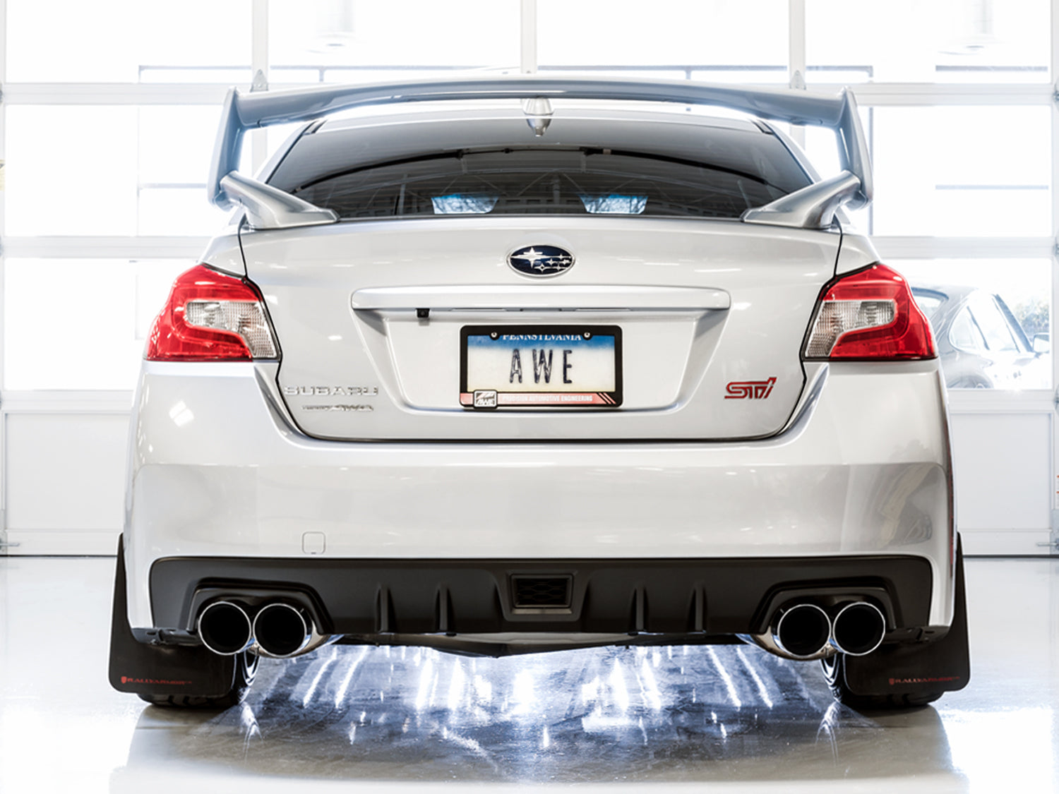 White VA WRX STI from directly behind showing AWE Touring chrome quad tips below the wing