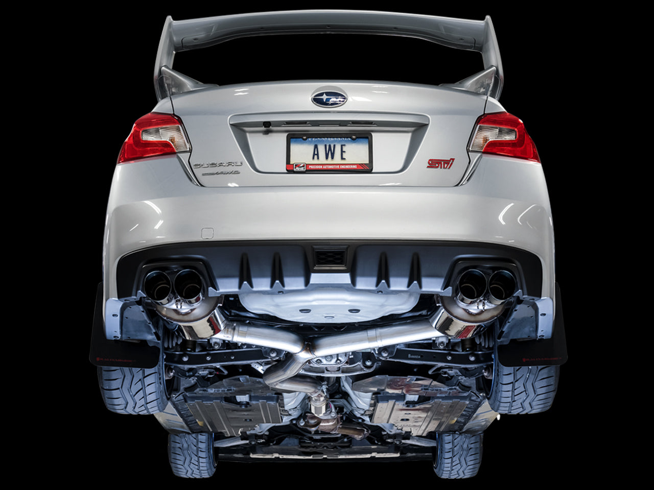 Underside of a VA WRX STI on a black backdrop showing the AWE Touring Edition routing