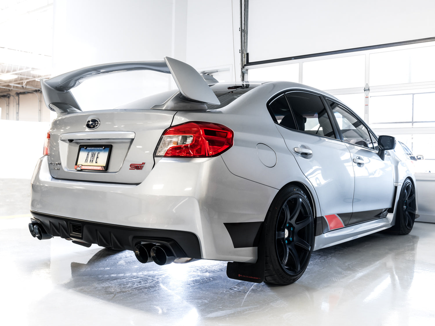 White VA STI rear three-quarter in a studio fitted with AWE Diamond Black Touring tips