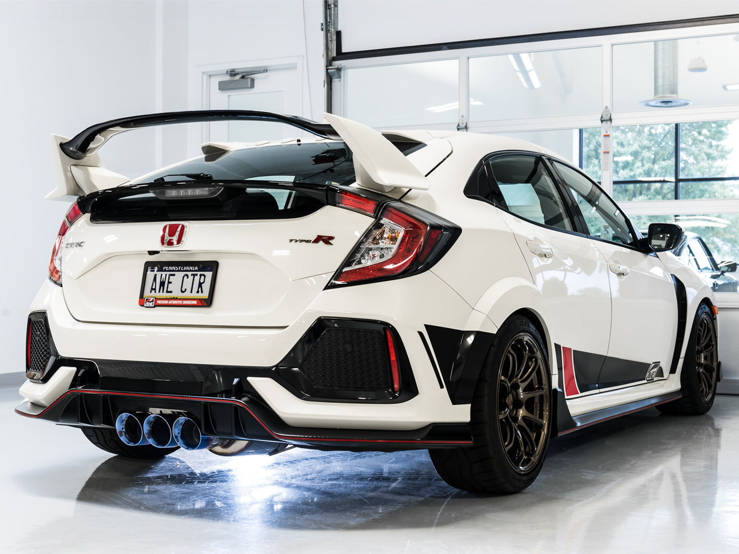 White FK8 Type R rear three-quarter view in a garage showing AWE Vapor Blue tips