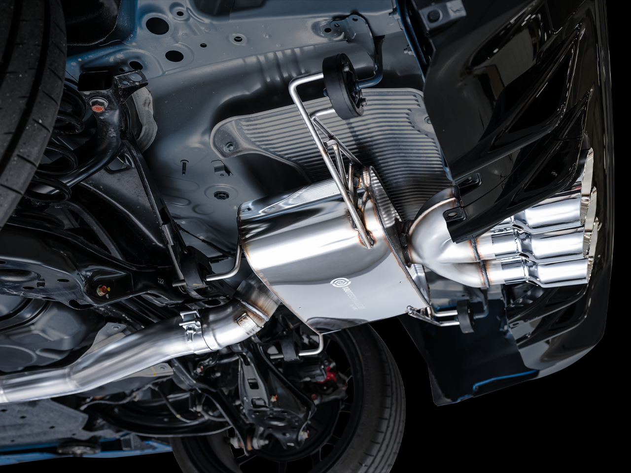 Close side view of the AWE Touring muffler and chrome triple tips under an FL5