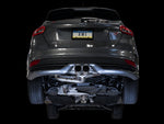 Low rear view of a gray Focus ST on black showing the AWE cat-back routed under the car