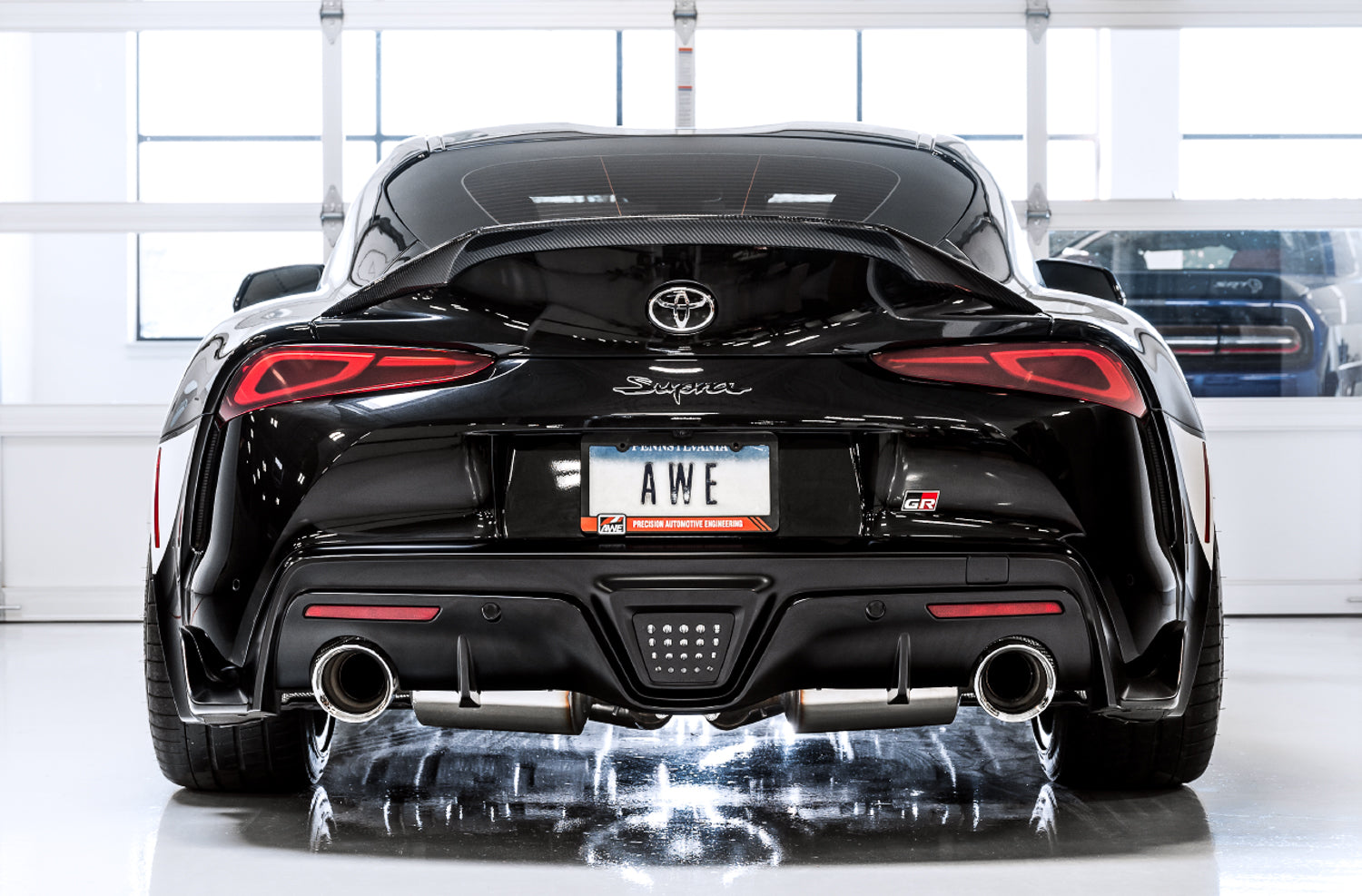 Black A90 Supra rear view in a white studio with AWE Non-Resonated Diamond Black tips