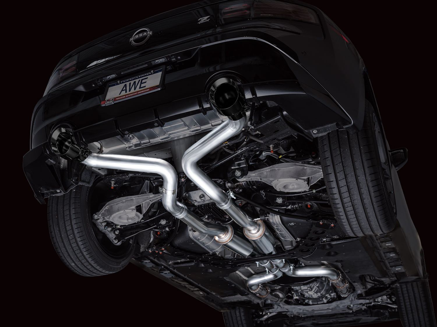 Side underbody view of the AWE Track Edition piping tucked under a black Nissan Z