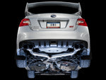 Underside of a white VA WRX STI on a black backdrop showing AWE Track Edition pipework