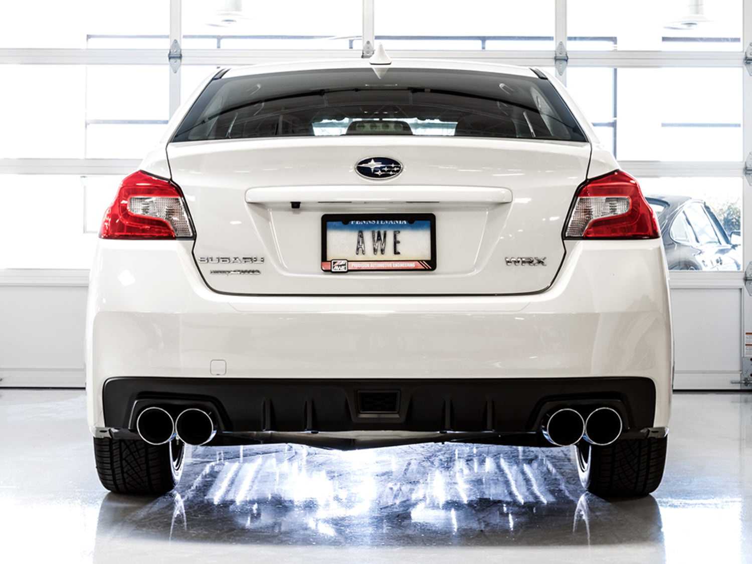 White VA WRX sedan from directly behind showing AWE Track Edition Chrome Silver quad tips