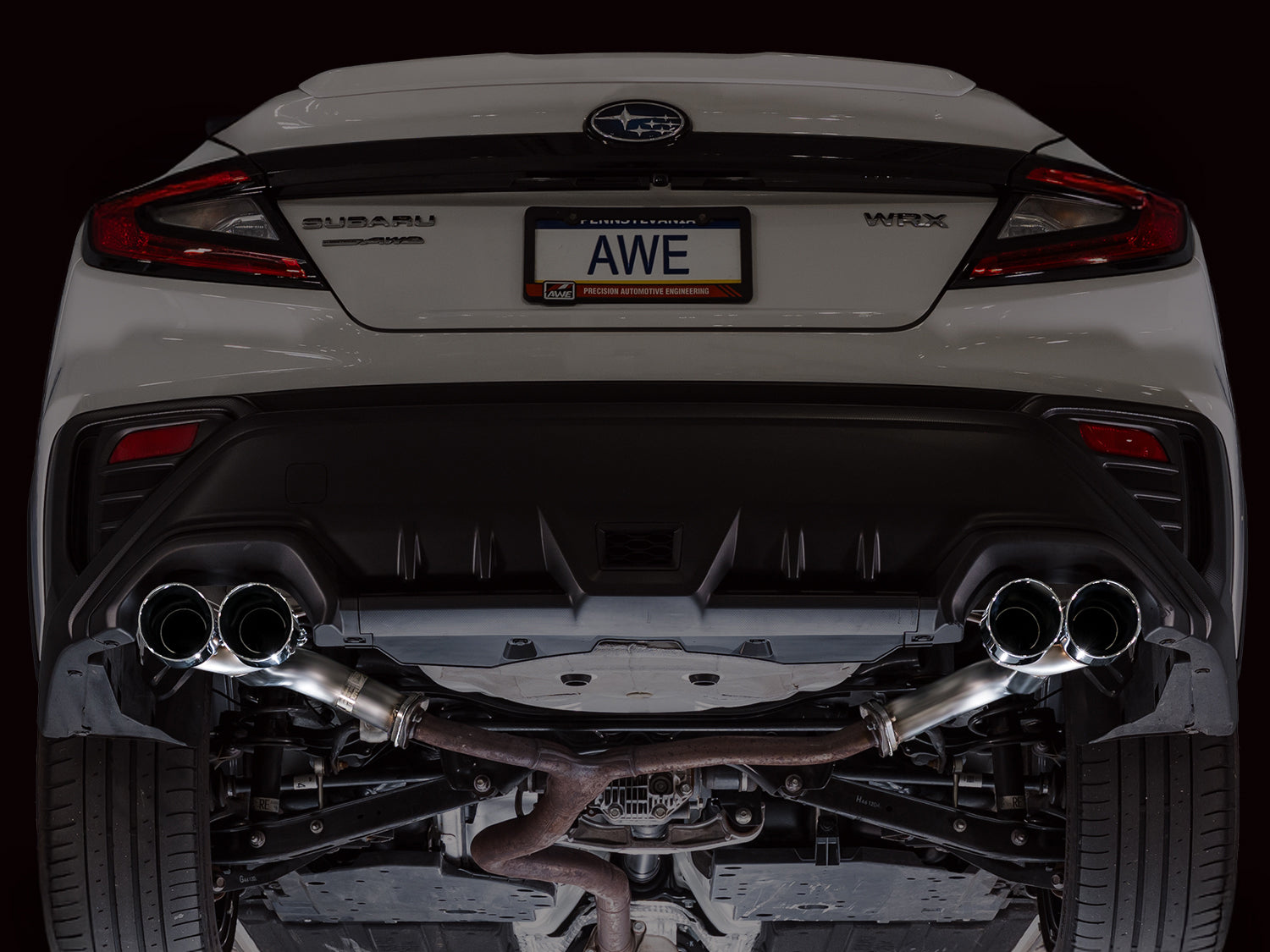 Rear of a white VB WRX on a lift with the AWE Track axle-back and quad Chrome tips
