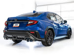 Rear three-quarter view of a blue VB WRX in a white studio with AWE Track Edition tips