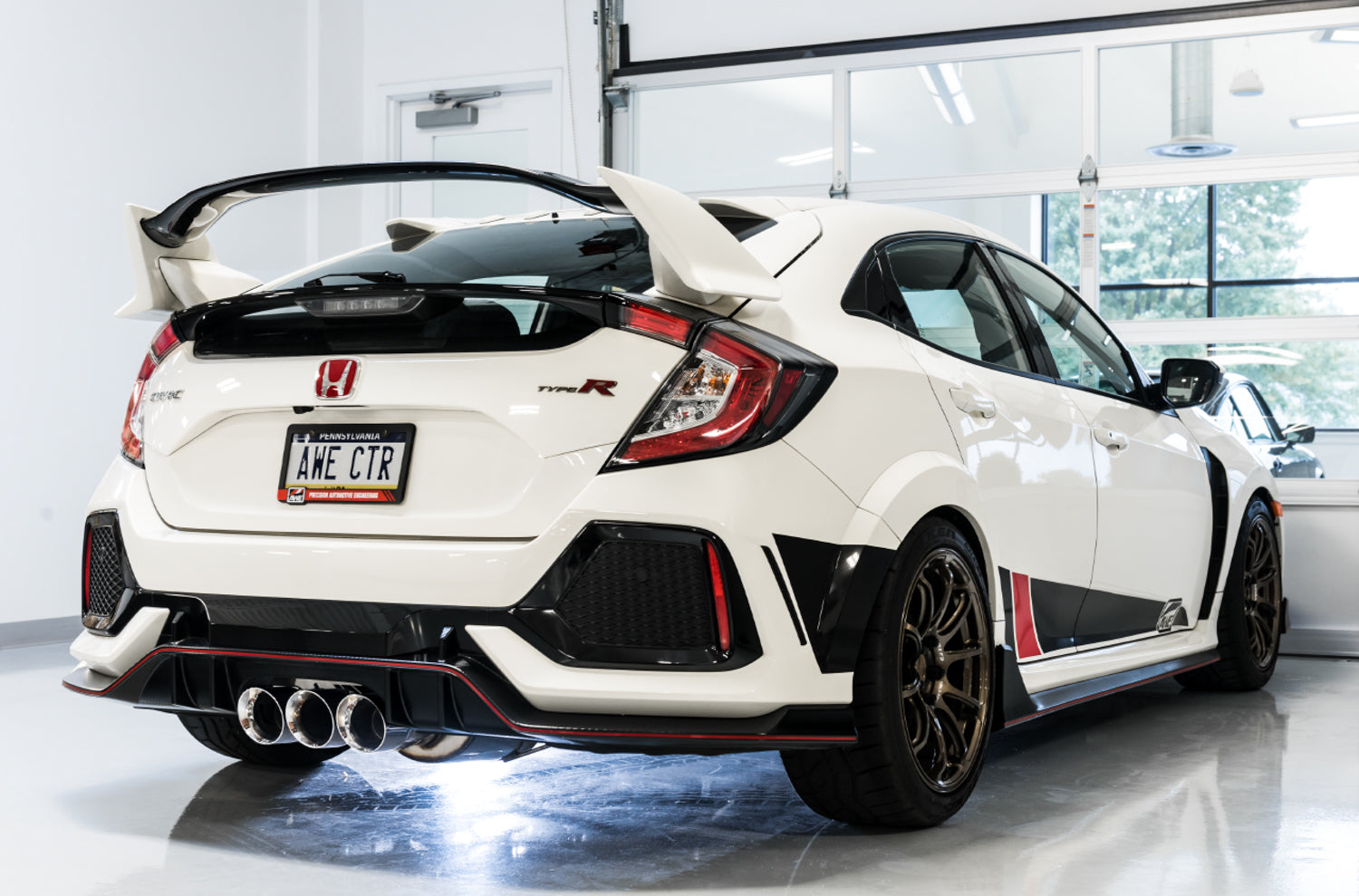 White FK8 Type R rear three-quarter view in a garage with AWE Track Edition tips
