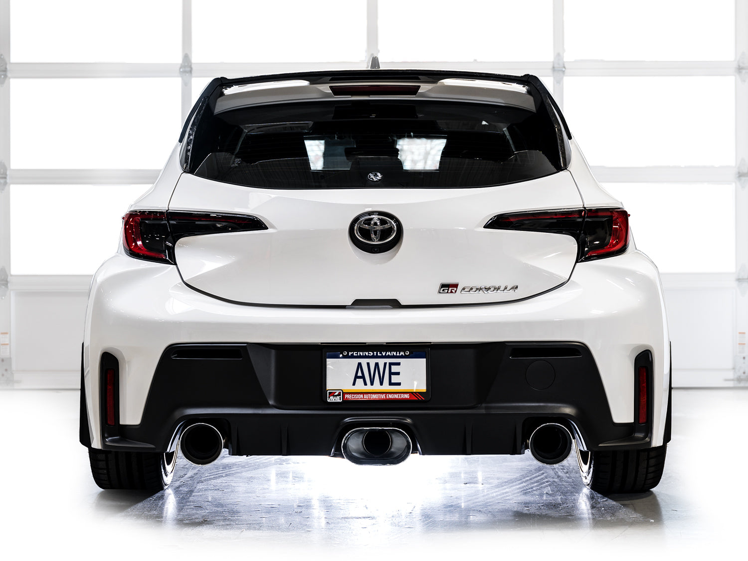 White Toyota GR Corolla from straight behind in a studio with AWE Track chrome tips