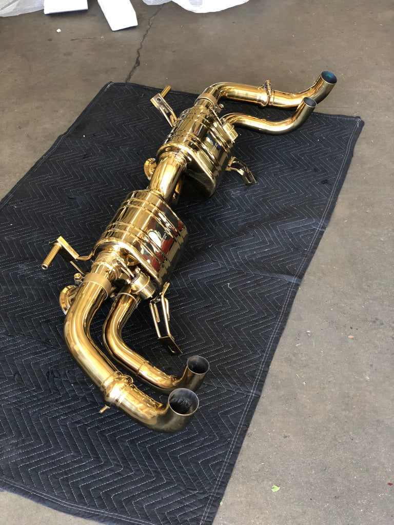 An side overview from the top of Valvetronic Designs Valved Sport Exhaust System (for Audi R8 V8 / V10)  on a black rug on the ground.