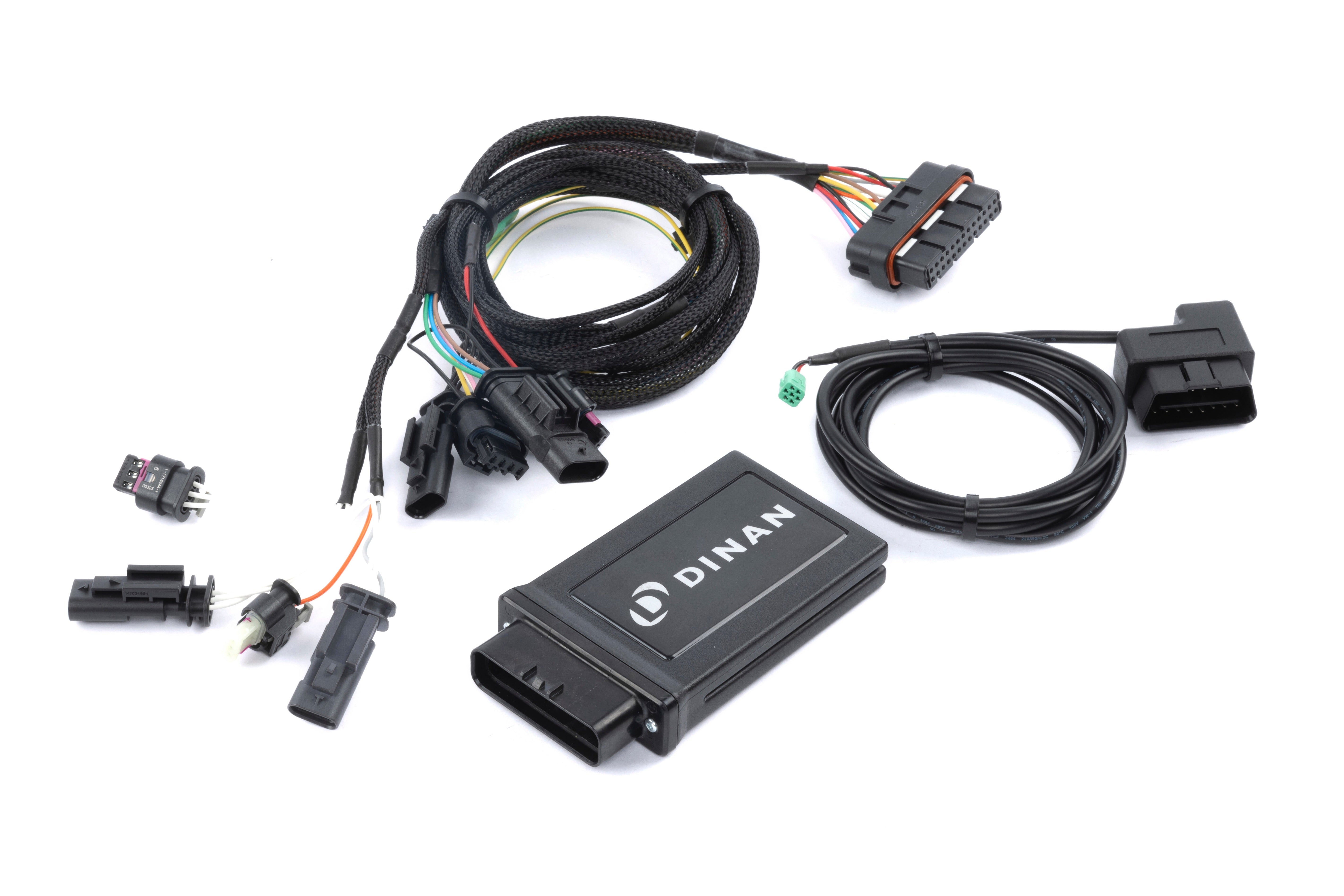 The complete Dinan PCU tuning kit, including the main control module, a high-quality plug-and-play wiring harness with OEM-style connectors, and an OBD-II integration cable for live data monitoring.