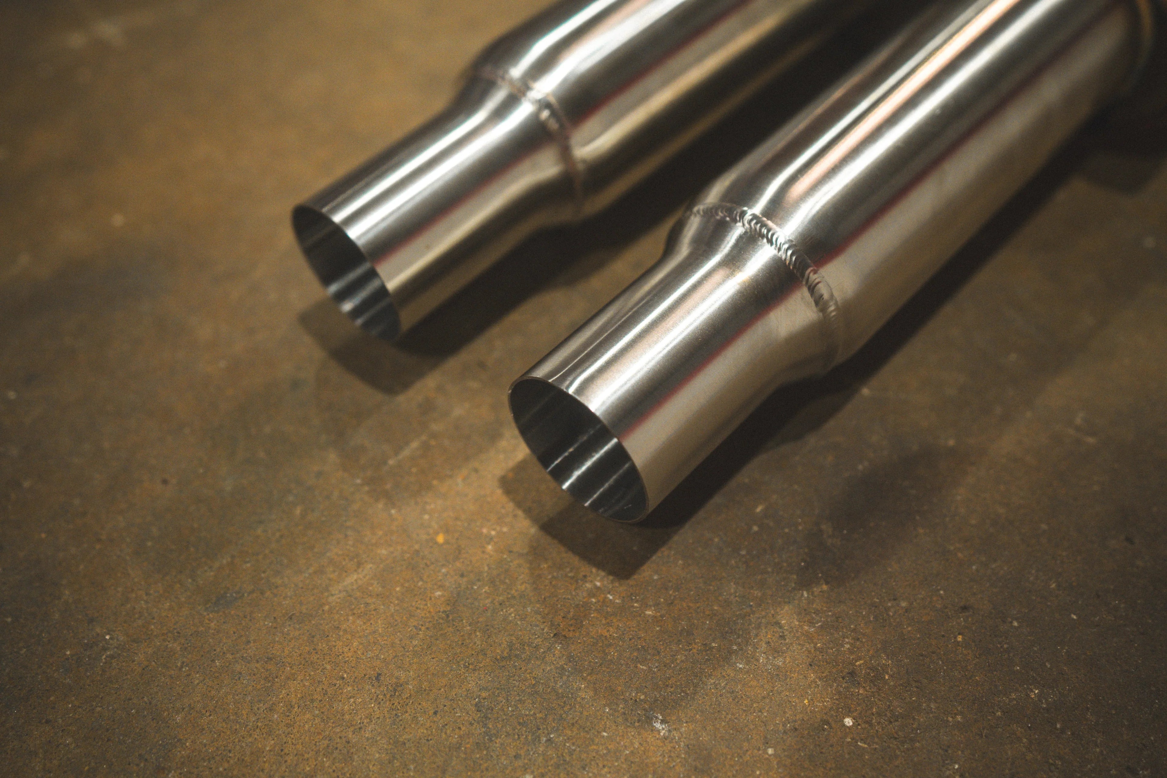 A close-up shot of the dual mid-pipe inlets showing the clean weld beads and the brushed finish of the stainless steel tubing.