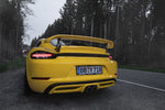 A close up view of TECHART Rear Spoiler II for Porsche 718 Cayman fitted on a yellow car 