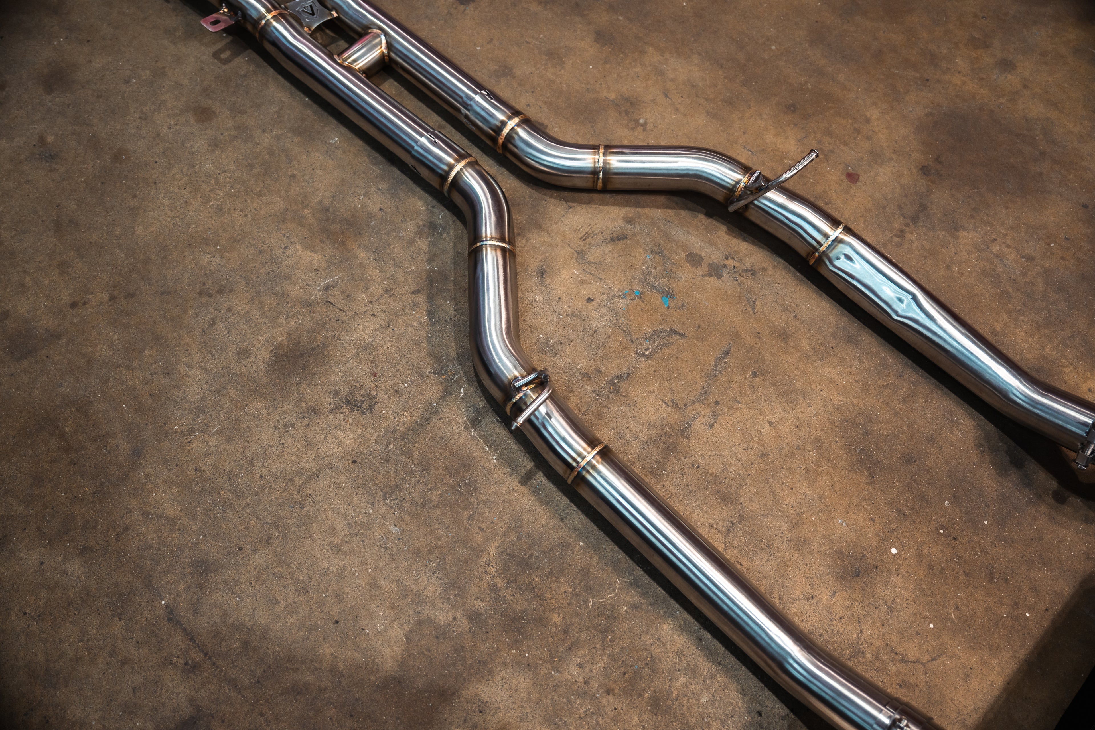 Top-down view of the long mid-pipes leading into the central muffler assembly.
